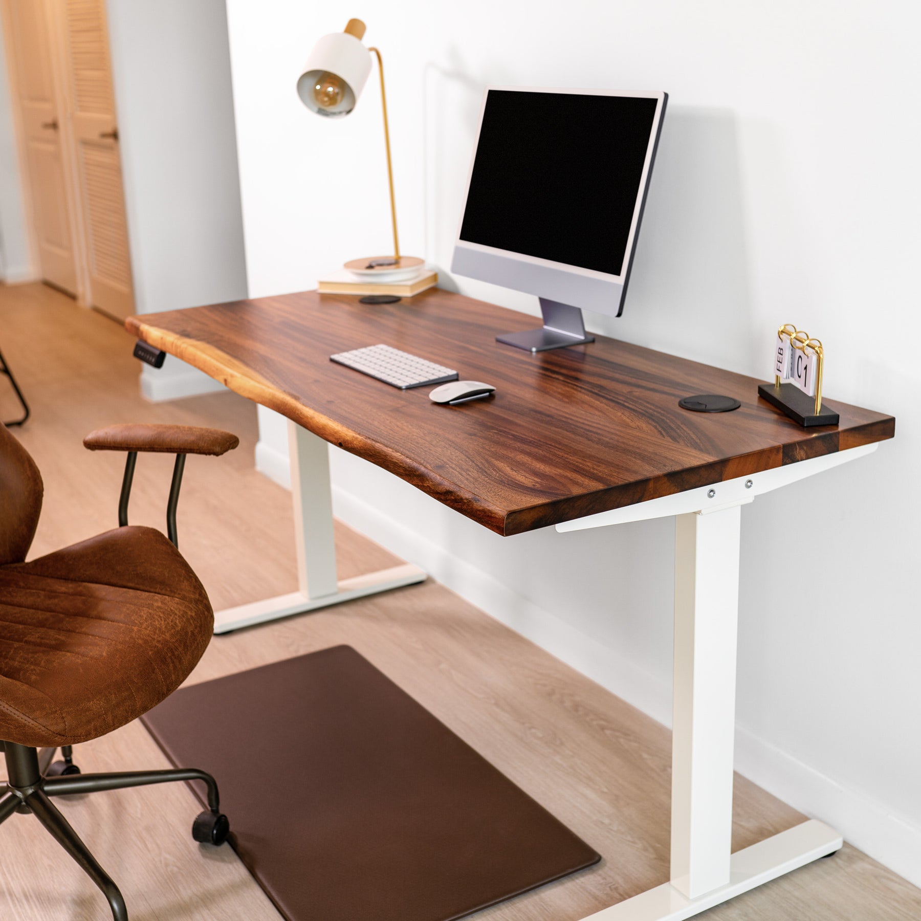 Adjustable standing desk with walnut wood, natural live edge top, and white dual motor legs.