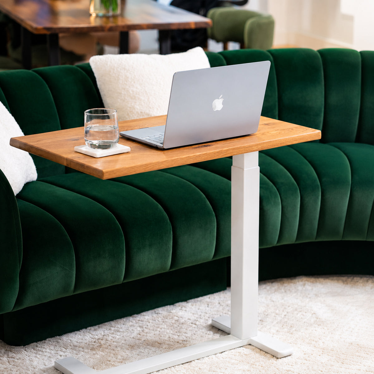 Solid white oak mobile laptop desk with natural live-edge top, white pneumatic frame, and rolling base