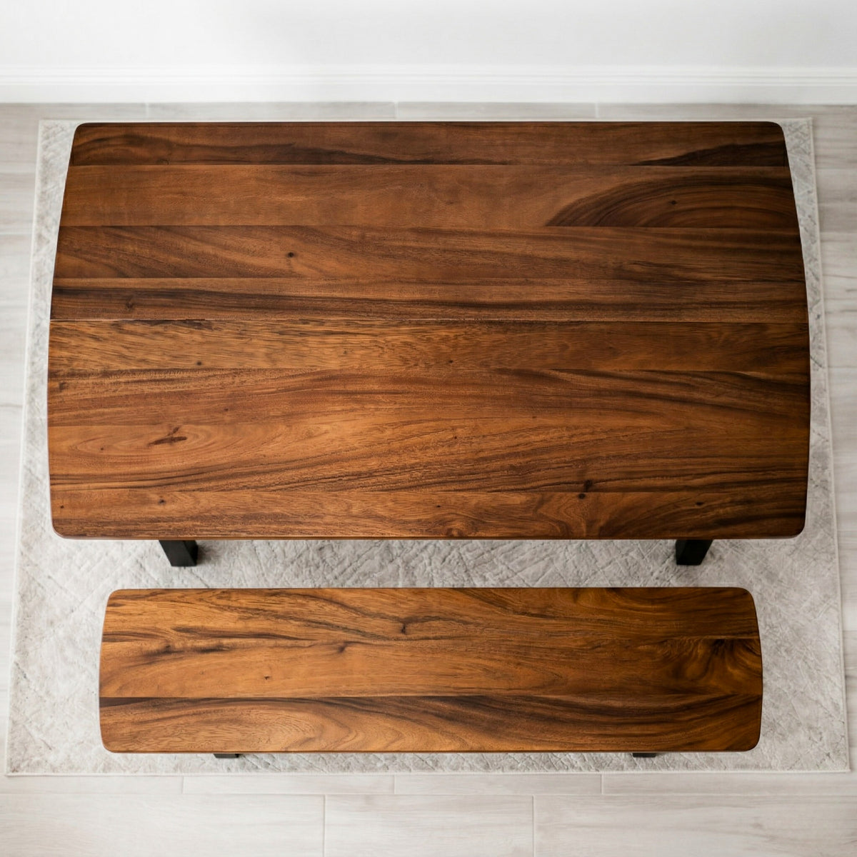 Solid walnut dining table with bench on a light gray floor.