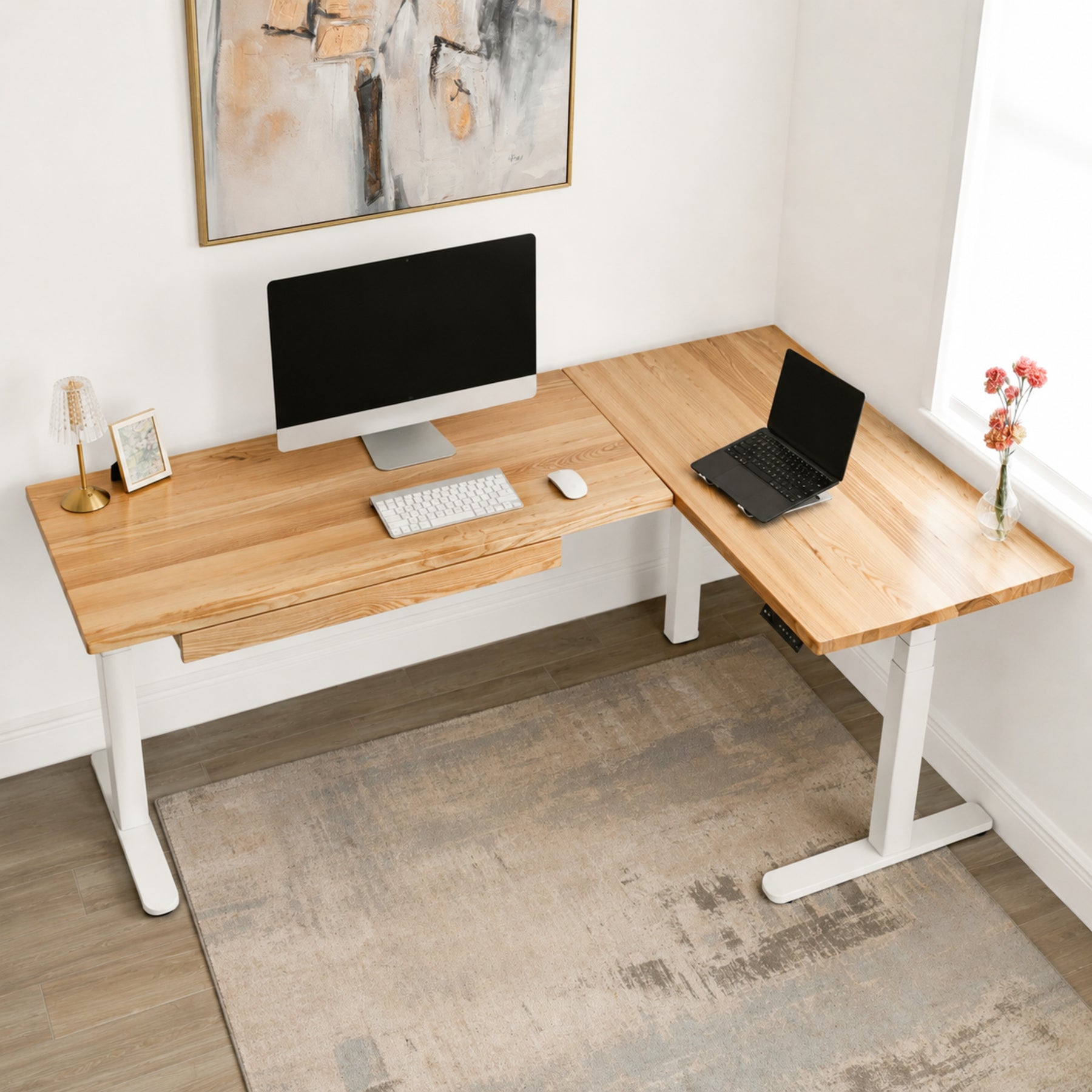 White oak L-shaped standing desk with computer setup in a home office.