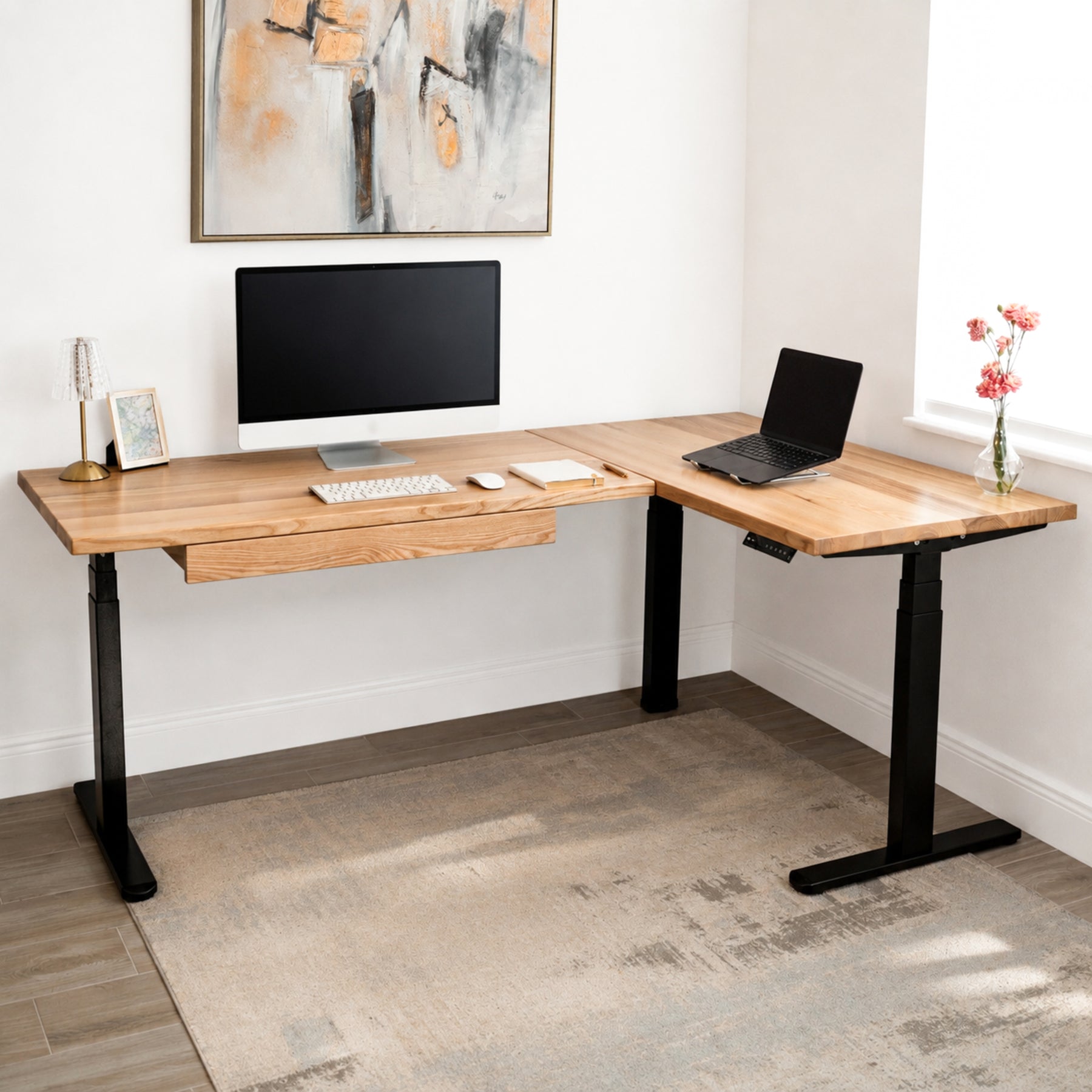 White oak L-shaped standing desk with computer setup in a home office.