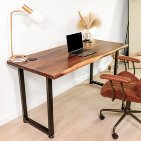 Chic walnut solid wood computer desk with live edge design, complemented by a brown office chair, laptop, modern desk lamp, and decorative accents, perfect for a contemporary home office setup.