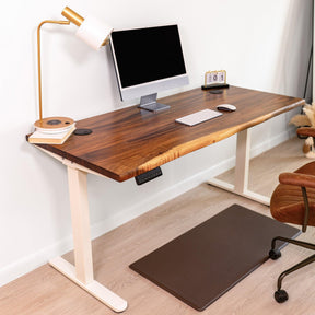 Perfect ergonomic home office setup featuring live edge wood desk with adjustable height legs in white color. 