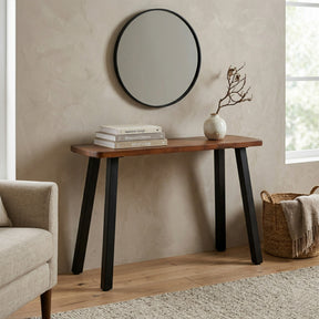 Solid walnut console table with black legs against a beige wall, featuring a mirror above and decor items on top.