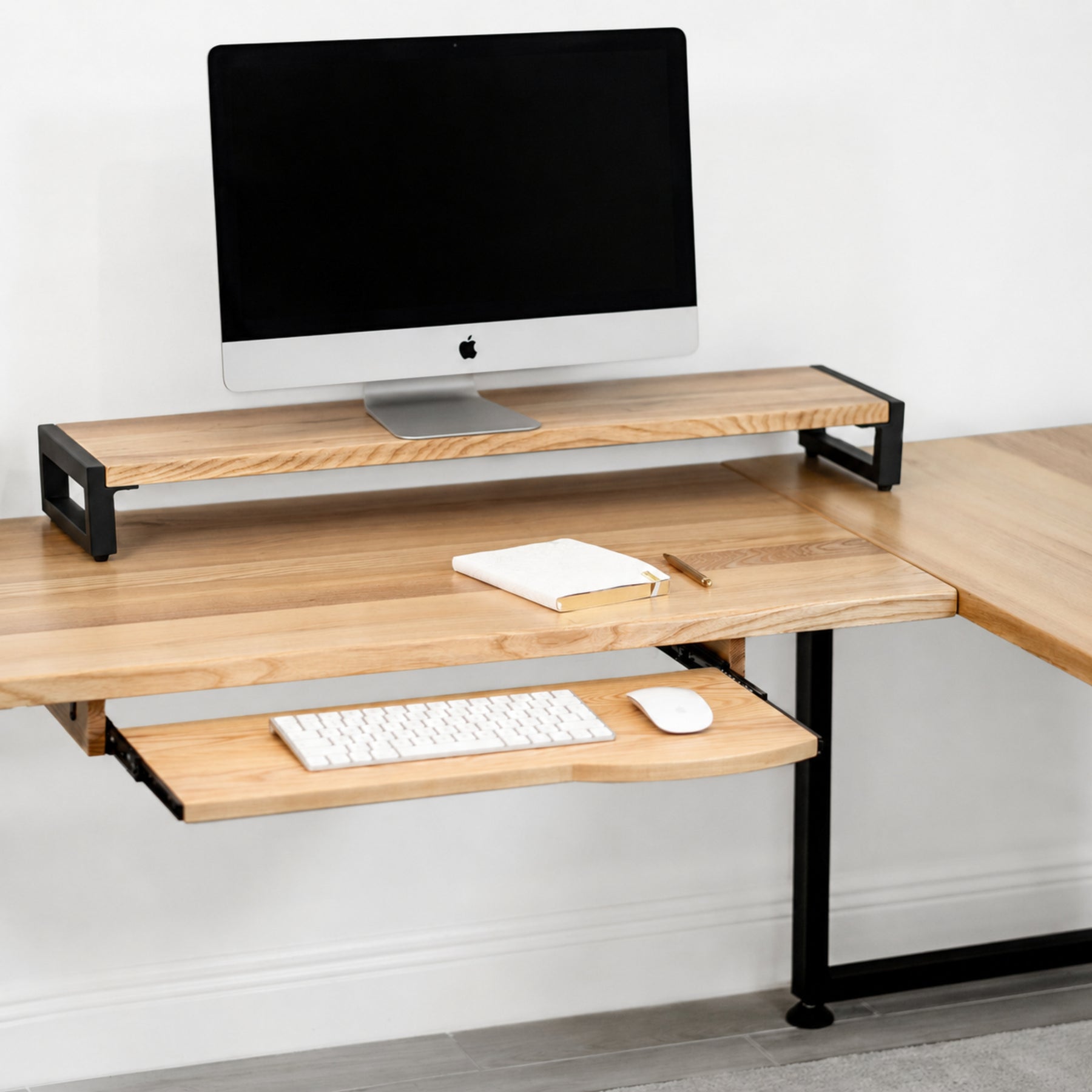 White oak L-shaped desk with keyboard tray, computer setup on a white background