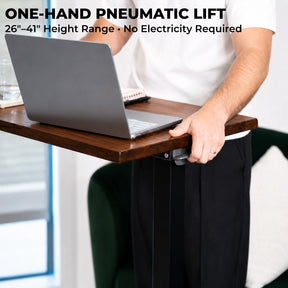 One-hand pneumatic height adjustment on a solid walnut laptop desk with a 26-to-41-inch range and no electricity