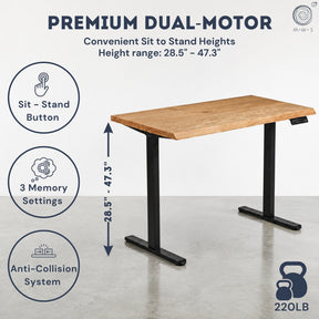 White oak standing desk with black sit-stand legs on a gray floor, featuring text about premium dual-motor height adjustment.