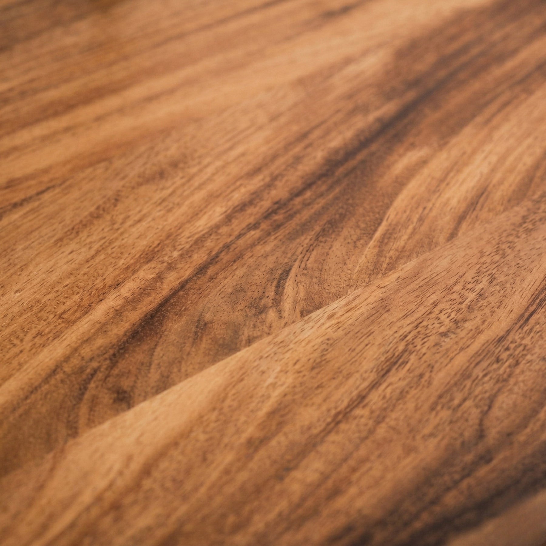 Close-up of a walnut desk with a warm brown color.