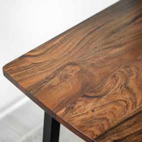 Close-up of a walnut table with a wavy grain pattern on a white background