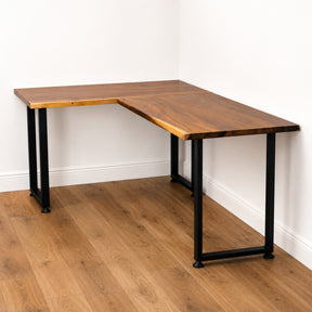 Walnut solid wood L-shaped desk with black metal legs on a wooden floor.