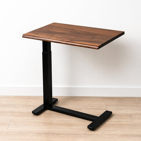 Solid walnut rolling laptop desk with live-edge top, black pneumatic frame, and low-profile wheeled base