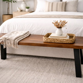Wooden bench with a blanket and decorative items in a bedroom setting