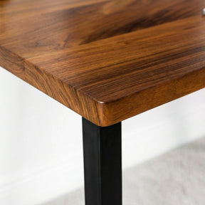 Close-up of a walnut table with a black metal leg on a light gray background