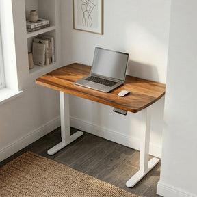 Narrow walnut standing desk with a laptop and mouse in a home office setting