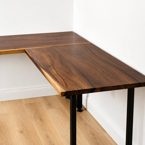 Walnut solid wood L-shaped desk against a white wall