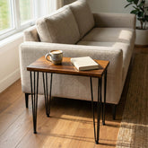Walnut Side Table with a cup and book next to a beige sofa in a room with a window.