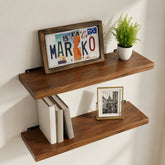 Walnut floating shelves with books, a framed picture, and a plant on a white wall.