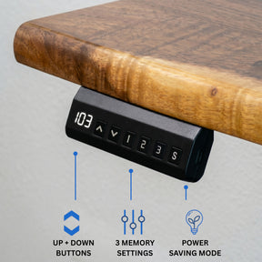 A black under-desk electronic control panel mounted beneath a wooden standing desk's edge, with blue callouts and icons explaining up/down buttons, 3 memory settings, and power-saving mode.