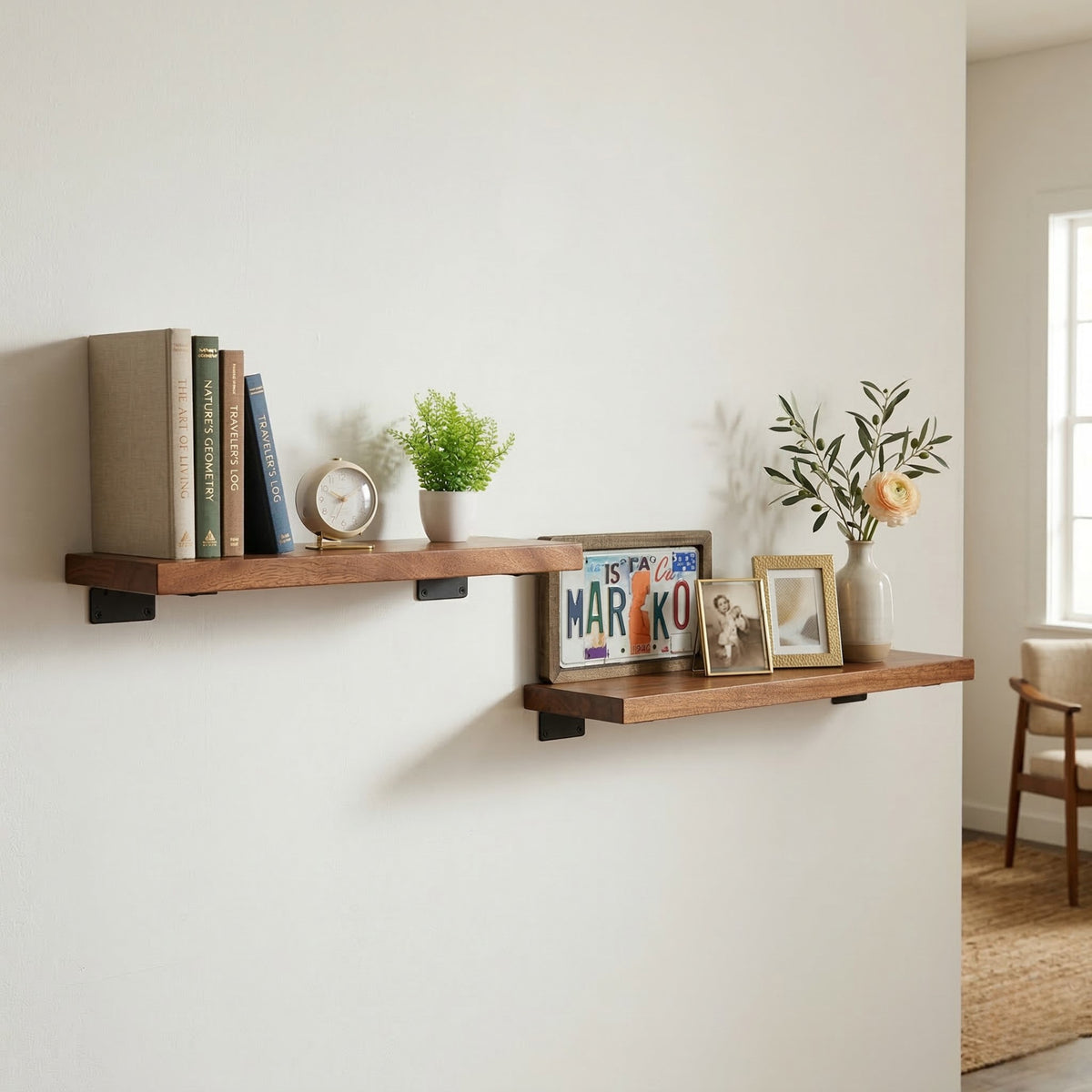 Walnut wall shelves with books, plants, and decorative items against a white wall.