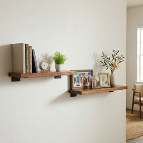 Walnut floating wall shelves with books, plants, and decorative items against a white wall.