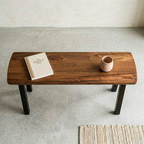 Wooden console table with a book and a cup on a concrete floor